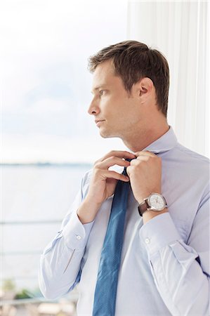 simsearch:693-07456224,k - Thoughtful businessman adjusting necktie in hotel Stock Photo - Premium Royalty-Free, Code: 693-07456212
