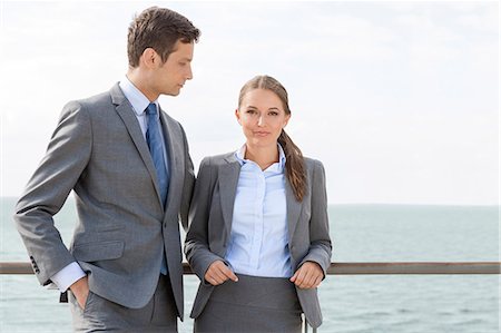 railing - Portrait of businesswoman with coworker leaning on terrace railing against sky Stock Photo - Premium Royalty-Free, Code: 693-07456235