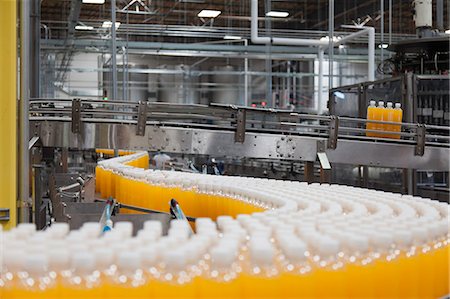 Packed bottles moving on conveyor belt Photographie de stock - Premium Libres de Droits, Code: 693-07456324