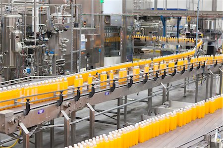 Packed bottles moving on conveyor belt in bottling industry Stock Photo - Premium Royalty-Free, Code: 693-07456326