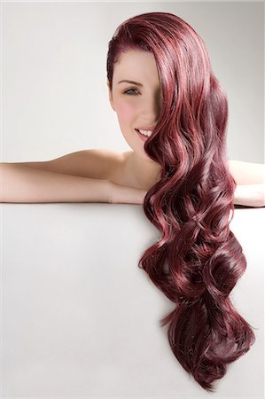 Beautiful woman with long red dyed hair against gray background Stockbilder - Premium RF Lizenzfrei, Bildnummer: 693-07456332