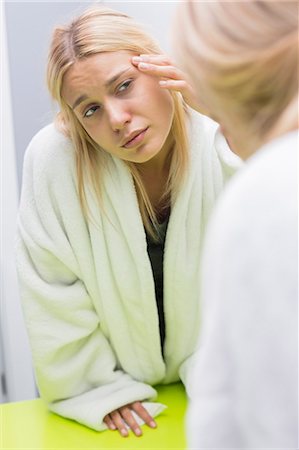 Woman looking at chest in mirror stock photo