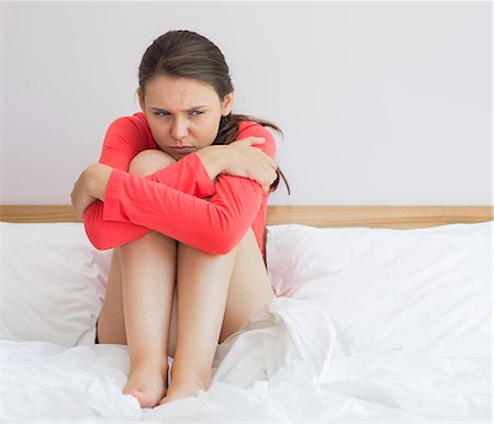 sad alone adult - Sad woman hugging knees on bed at home Photographie de stock - Premium Libres de Droits, Code: 693-07456402