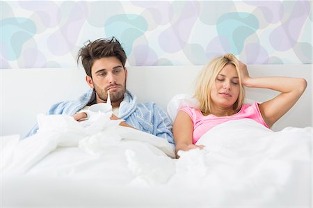 sick couple - Frustrated sick couple lying in bed at home Stock Photo - Premium Royalty-Free, Code: 693-07456412