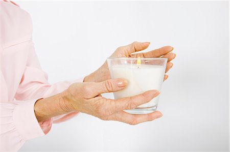 people holding candle - Cropped image of senior businesswoman holding lit candle in office Photographie de stock - Premium Libres de Droits, Code: 693-07456480