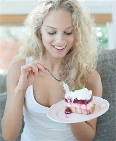 eating sofa - Beautiful woman having raspberry cake in house Stock Photo - Premium Royalty-Free, Code: 693-07542094