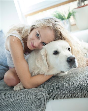 people hugging dogs - Beautiful woman hugging dog on sofa Stock Photo - Premium Royalty-Free, Code: 693-07542104