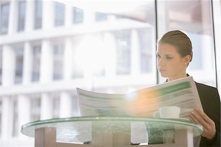 people reading newspapers - Businesswoman reading newspaper at office cafeteria Stock Photo - Premium Royalty-Free, Code: 693-07542122