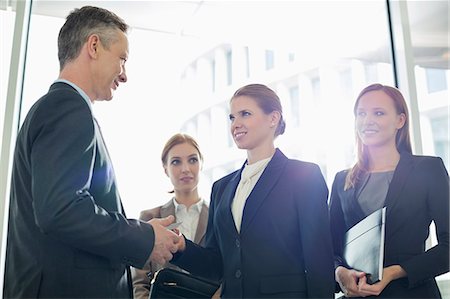 presentando - Businesswoman giving her card to businessman in office Foto de stock - Sin royalties Premium, Código: 693-07542134