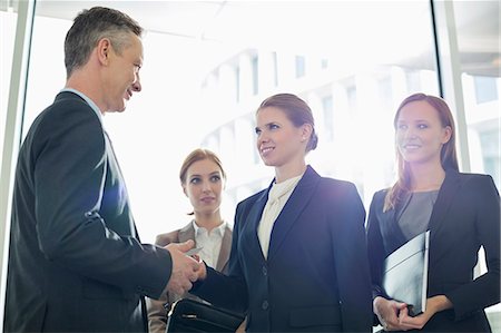 Businesswoman giving her card to businessman in office Stock Photo - Premium Royalty-Free, Code: 693-07542134