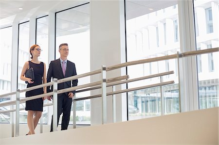 simsearch:693-07672655,k - Business people walking by railing in office Stock Photo - Premium Royalty-Free, Code: 693-07542149