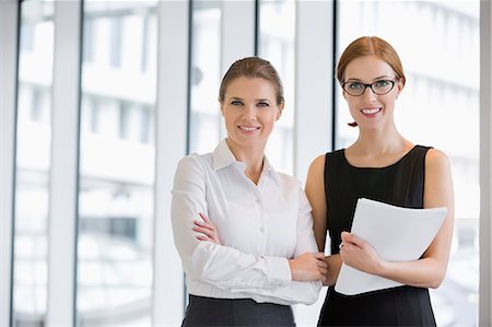 stand - Portrait of confident businesswomen with documents in office Stock Photo - Premium Royalty-Free, Code: 693-07542152