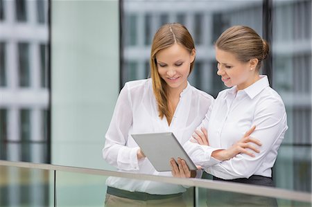 relate (co-workers) - Businesswomen using digital tablet in office Stock Photo - Premium Royalty-Free, Code: 693-07542168