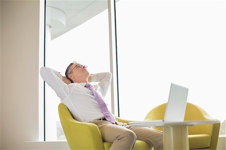 relaxing laptop - Mature businessman relaxing in lobby Stock Photo - Premium Royalty-Free, Code: 693-07542171