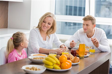 savoureux - Happy family of three having breakfast at table Photographie de stock - Premium Libres de Droits, Code: 693-07542219