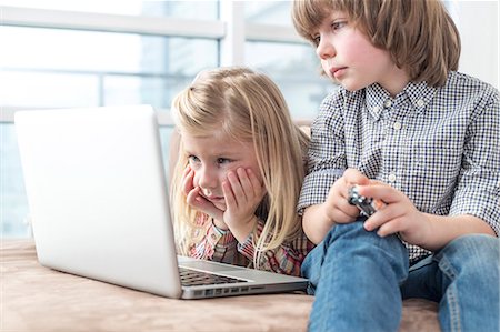 simsearch:6108-05874643,k - Brother and sister looking at laptop in living room Foto de stock - Sin royalties Premium, Código: 693-07542257