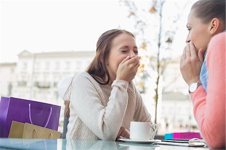 Happy women sharing secrets at outdoor cafe Stock Photo - Premium Royalty-Free, Code: 693-07542316