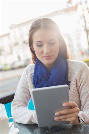 europe woman scarf - Woman using tablet PC at sidewalk cafe Stock Photo - Premium Royalty-Free, Code: 693-07542312