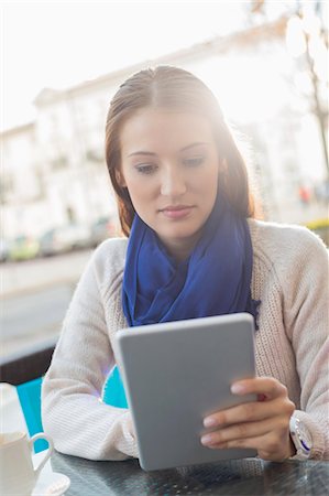 scarf - Woman using tablet PC at sidewalk cafe Foto de stock - Sin royalties Premium, Código: 693-07542312