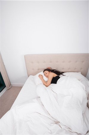 High angle view of young woman sleeping in bed Fotografie stock - Premium Royalty-Free, Codice: 693-07542353