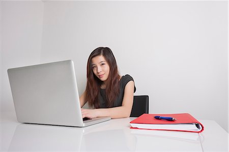 Portrait of confident young businesswoman using laptop in office Foto de stock - Sin royalties Premium, Código: 693-07672537