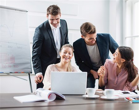 simsearch:693-06379459,k - Successful young business people using laptop at desk in office Stock Photo - Premium Royalty-Free, Code: 693-07672546