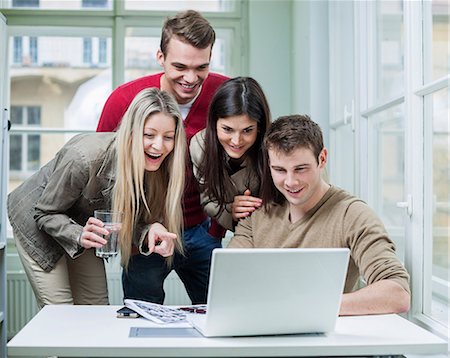 smiling brunette man looking at laptop - Happy business people using laptop in meeting Stock Photo - Premium Royalty-Free, Code: 693-07672560