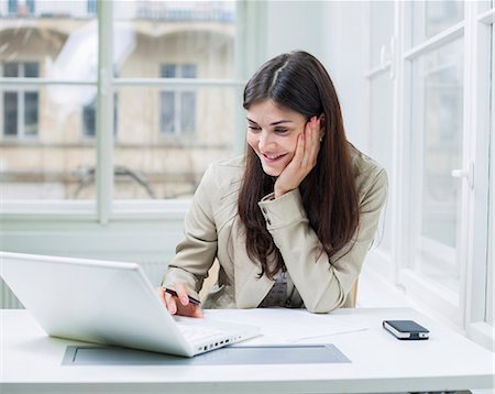 entrepreneur in office - Young businesswoman using laptop at office desk Stock Photo - Premium Royalty-Free, Code: 693-07672562