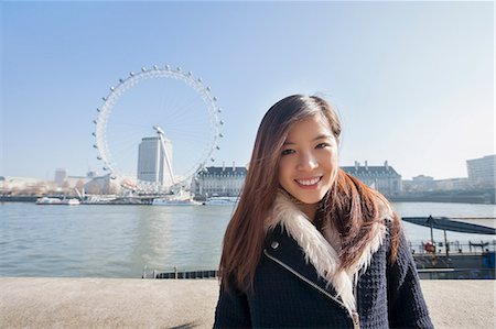 simsearch:693-07542370,k - Portrait of happy young woman standing against London Eye at London, England, UK Foto de stock - Royalty Free Premium, Número: 693-07672572