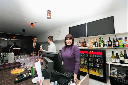 restaurant male cashier - Portrait of female cashier with manager and bartender at bar counter Stock Photo - Premium Royalty-Free, Code: 693-07672580