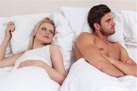 Young man ignoring woman in bed Stock Photo - Premium Royalty-Free, Code: 693-07672713