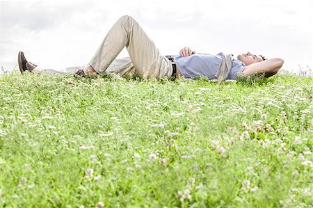 Full length of young man lying on grass against sky Photographie de stock - Premium Libres de Droits, Code: 693-07672794