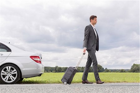 Full length side view of young businessman with suitcase leaving broken down car at countryside Photographie de stock - Premium Libres de Droits, Code: 693-07672838