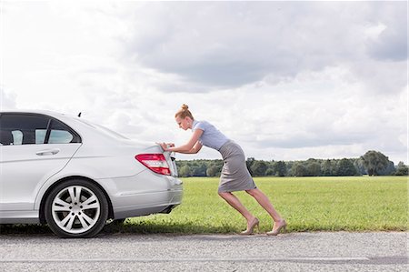 simsearch:693-08127141,k - Full length side view of businesswoman pushing broken down car at countryside Foto de stock - Sin royalties Premium, Código: 693-07672841