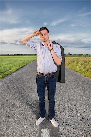 exhausted man on the road - Full length of tired young man standing on empty rural road Stock Photo - Premium Royalty-Free, Code: 693-07672868