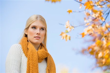 Low angle view of thoughtful young woman against sky Stock Photo - Premium Royalty-Free, Code: 693-07672916