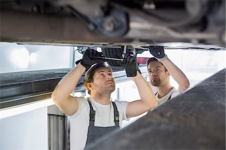 Maintenance engineers repairing car in workshop Photographie de stock - Premium Libres de Droits, Code: 693-07672947