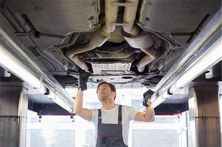 Mid adult male repair worker repairing car in workshop Stock Photo - Premium Royalty-Free, Code: 693-07672943