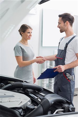 Young repair worker shaking hands with customer in car workshop Stock Photo - Premium Royalty-Free, Code: 693-07672956
