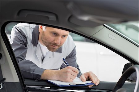 simsearch:693-07672962,k - Male mechanic with clipboard checking car's interior in repair shop Stock Photo - Premium Royalty-Free, Code: 693-07672965