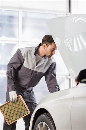 simsearch:693-07672952,k - Young automobile mechanic examining car in automobile shop Stock Photo - Premium Royalty-Free, Code: 693-07672963