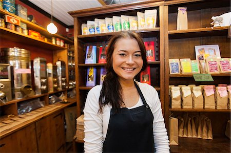 simsearch:693-06120779,k - Portrait of female salesperson smiling in coffee shop Fotografie stock - Premium Royalty-Free, Codice: 693-07672986