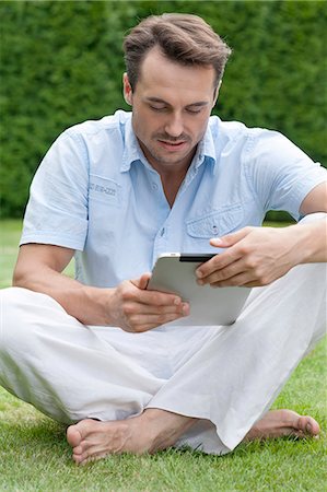 simsearch:693-07673302,k - Full length of young man using digital tablet in park Stock Photo - Premium Royalty-Free, Code: 693-07673050