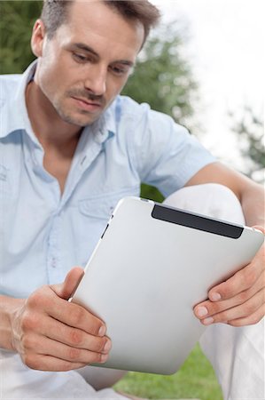 simsearch:693-07673302,k - Young man using digital tablet in park Stock Photo - Premium Royalty-Free, Code: 693-07673064
