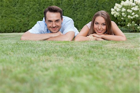 simsearch:693-07672803,k - Portrait of smiling young couple relaxing on grass in park Stock Photo - Premium Royalty-Free, Code: 693-07673060