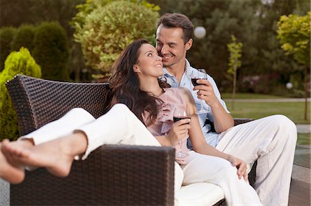 females drinking - Romantic young holding wine glasses on easy chair in park Stock Photo - Premium Royalty-Free, Code: 693-07673071