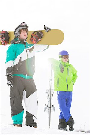 standing on snowboarding - Full length of young men with snowboards in snow Foto de stock - Sin royalties Premium, Código: 693-07673094