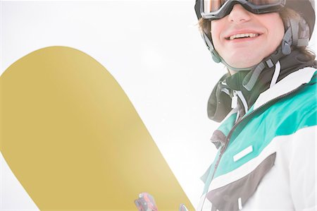 snowboarding - Smiling young man holding snowboard Photographie de stock - Premium Libres de Droits, Code: 693-07673097