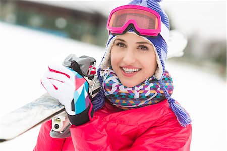 ski goggles person - Beautiful young woman carrying skis in snow Stock Photo - Premium Royalty-Free, Code: 693-07673107