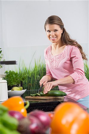 simsearch:693-07912779,k - Portrait of happy woman cutting cucumber at kitchen counter Foto de stock - Sin royalties Premium, Código: 693-07673239